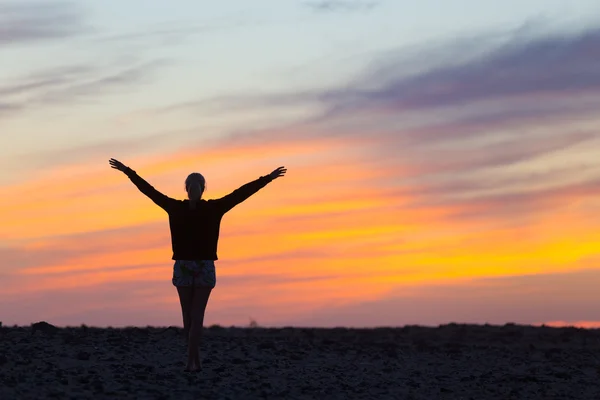 Frau genießt Freiheit bei Sonnenuntergang. — Stockfoto