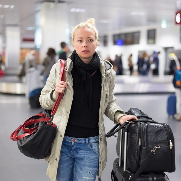 Female traveler transporting luggage in airport. — Stock Photo, Image