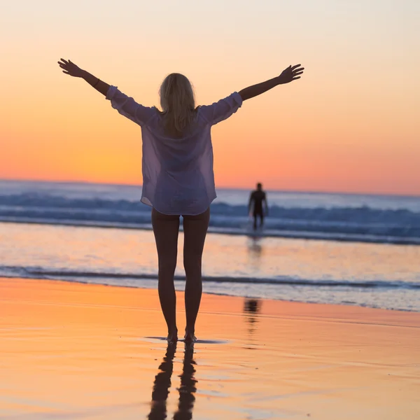 Free woman enjoying vacations on beach at sunset. — Stock Photo, Image