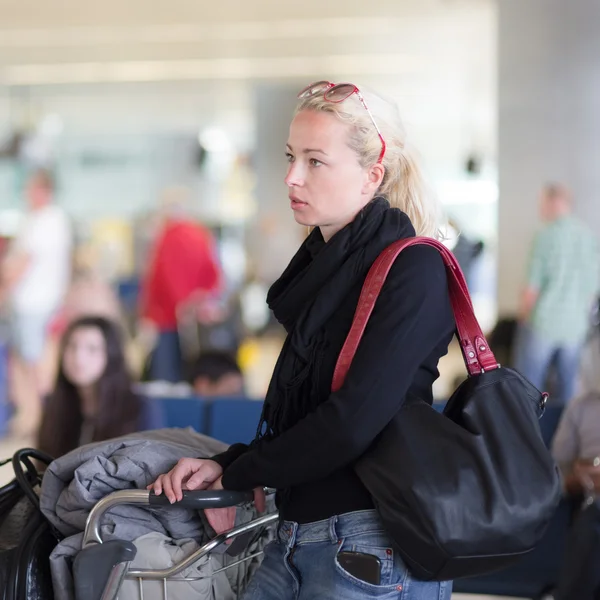 Viajante feminino usando telefone celular enquanto espera no aeroporto . — Fotografia de Stock