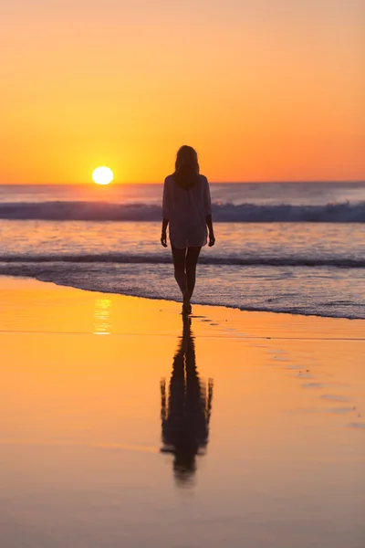 Bayan kumsalda gün batımı yürüyüş. — Stok fotoğraf