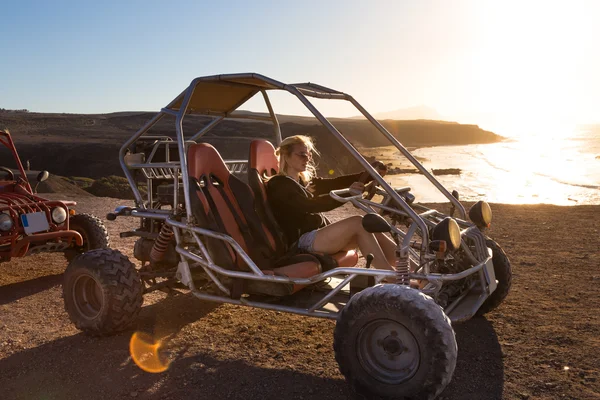 Mujer conduciendo quadbike al atardecer . — Foto de Stock