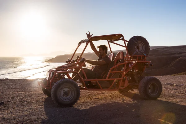 Homem dirigindo quadbike no por do sol . — Fotografia de Stock