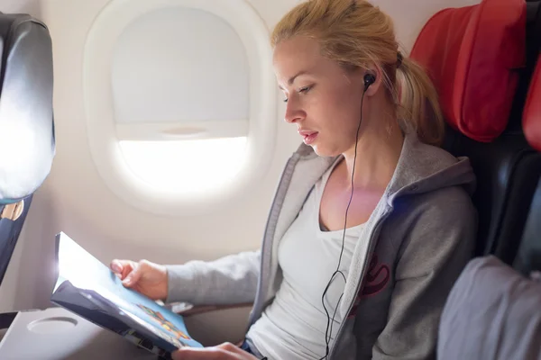 Kobieta czytania magazynu na samolot. — Zdjęcie stockowe