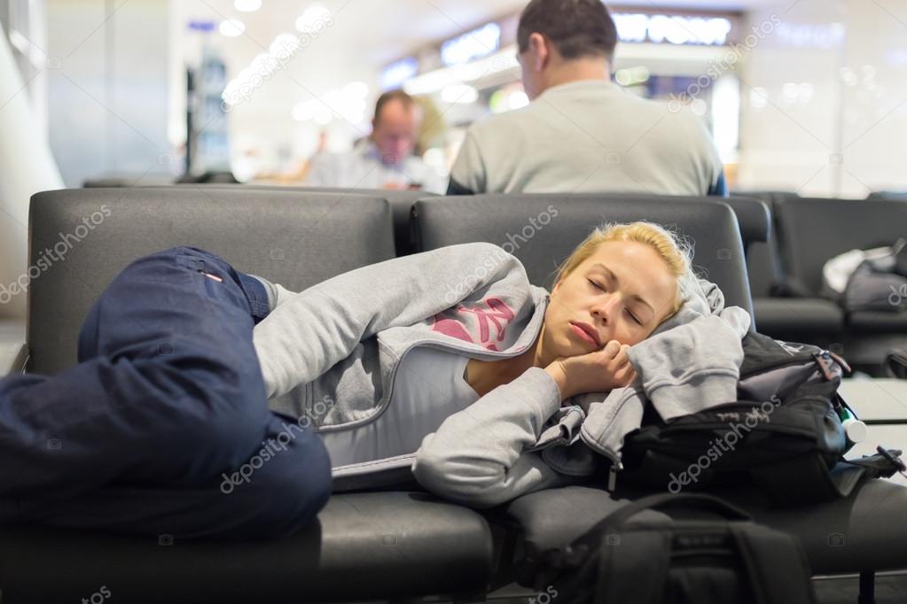 Tired female traveler sleeping on airport.