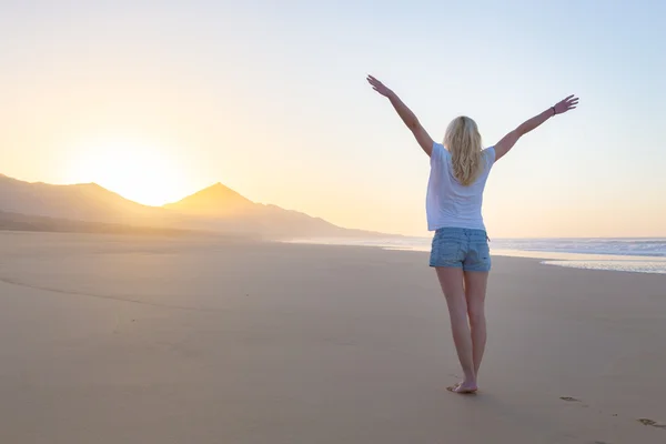 Free woman enjoying freedom on beach at sunrise. — Stock Photo, Image