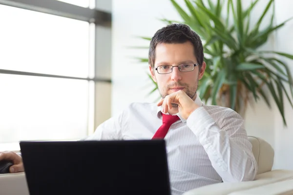 Portrait of businessman working on laptop computer — Stock Photo, Image