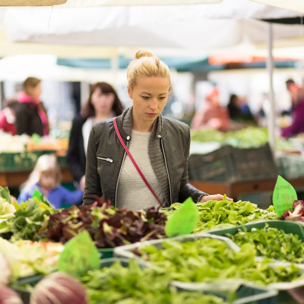 Mujer comprando verduras en el mercado local de alimentos . — Foto de Stock