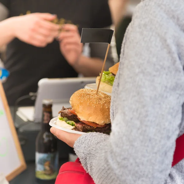 Beef burgers being served on street food stall