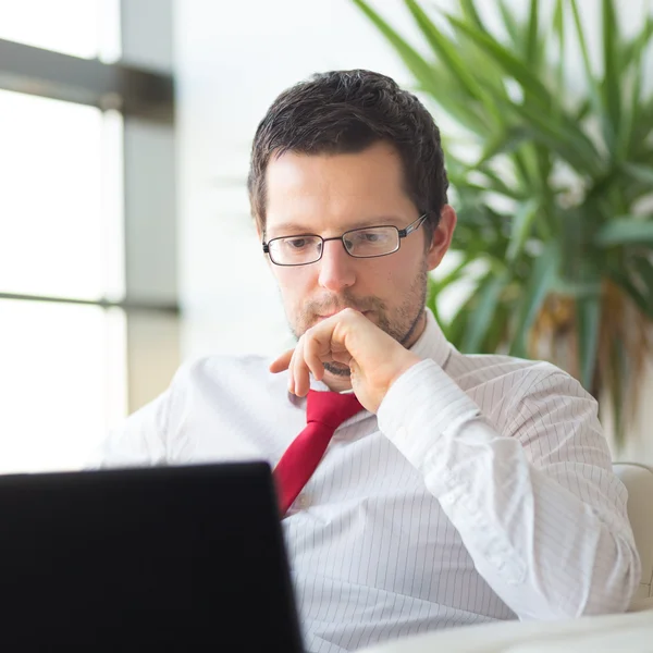 Geschäftsmann liest im Büro am Laptop. — Stockfoto