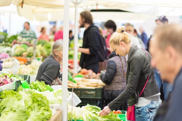 Mujer comprando verduras en el mercado local de alimentos . — Foto de Stock