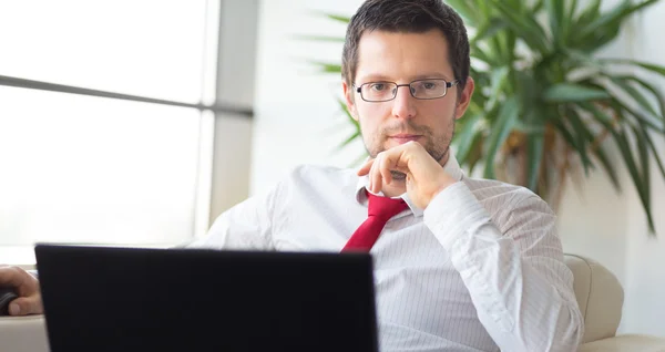 Retrato del hombre de negocios que trabaja en el ordenador portátil — Foto de Stock