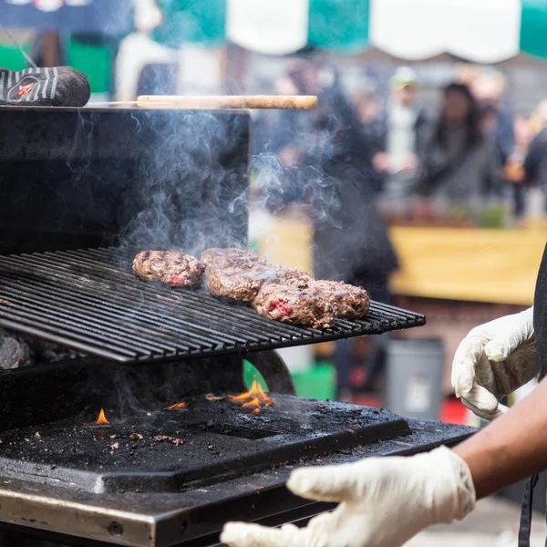 Burgers de boeuf grillés sur le grill de la stalle de nourriture . — Photo