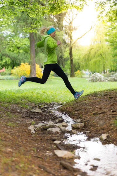 Sportovní mladá běžkyně v městském parku. — Stock fotografie