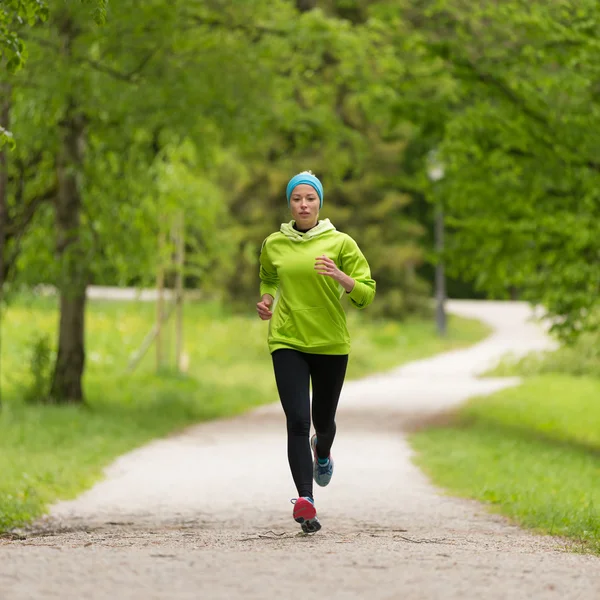 Sportovní mladá běžkyně v městském parku.. — Stock fotografie