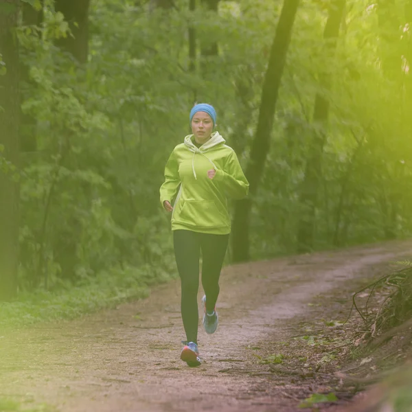 Sportieve jonge vrouwelijke atleet in het bos. — Stockfoto