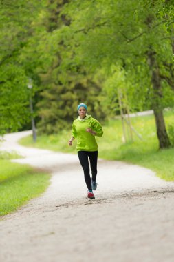 Şehir parkında sportif genç bayan koşucu..