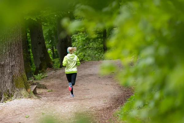 Sportliche junge Läuferin im Wald. — Stockfoto