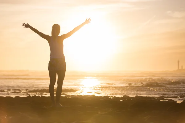 Mujer libre disfrutando de la libertad en la playa al atardecer . —  Fotos de Stock