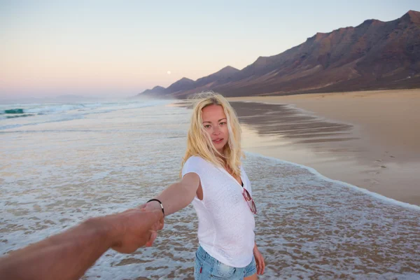Romántica pareja cogida de la mano en la playa . —  Fotos de Stock