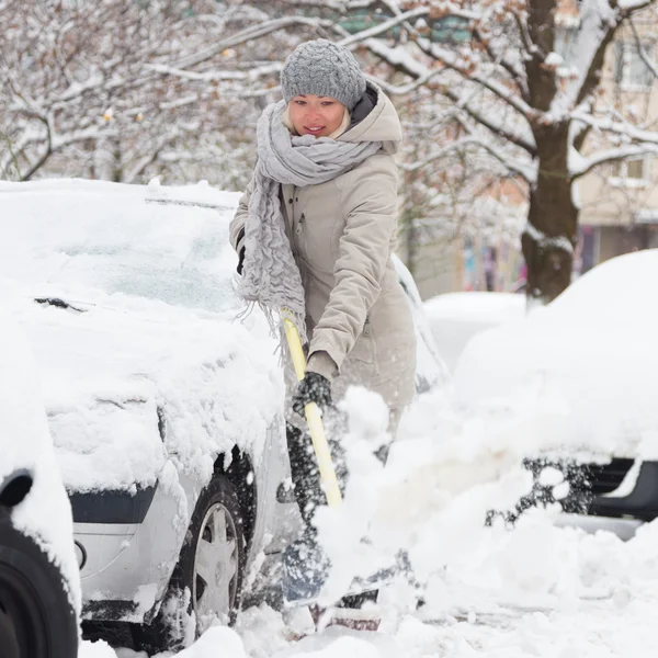 Mujer independiente paleando nieve en invierno . —  Fotos de Stock