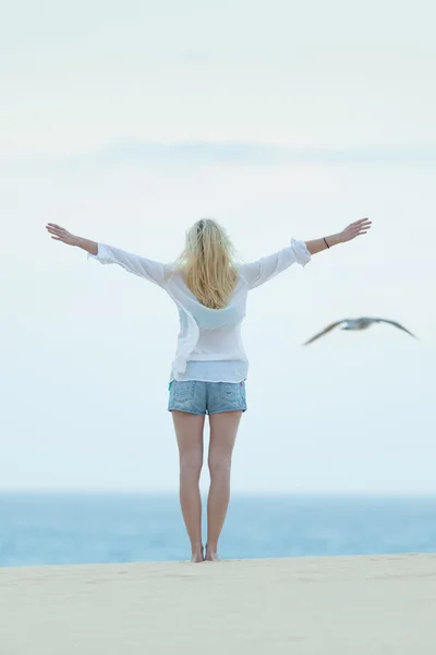 Freie Frau genießt Freiheit am Strand in der Abenddämmerung. — Stockfoto