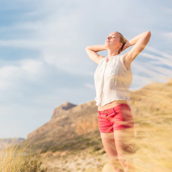 Kostenlose glückliche Frau genießt Sonne im Urlaub. — Stockfoto