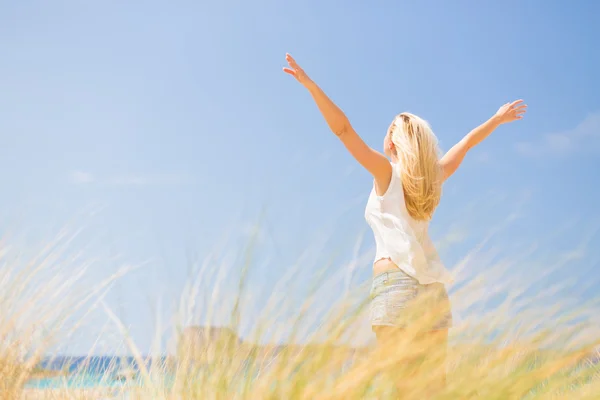 Kostenlose glückliche Frau genießt Sonne im Urlaub. — Stockfoto