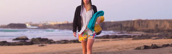 Mulher desportiva andando na praia de areia ao pôr do sol . — Fotografia de Stock