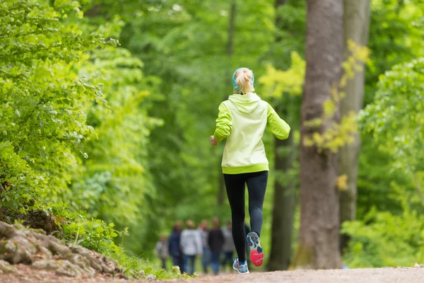 Sportovní mladé běžkyně v lese. — Stock fotografie