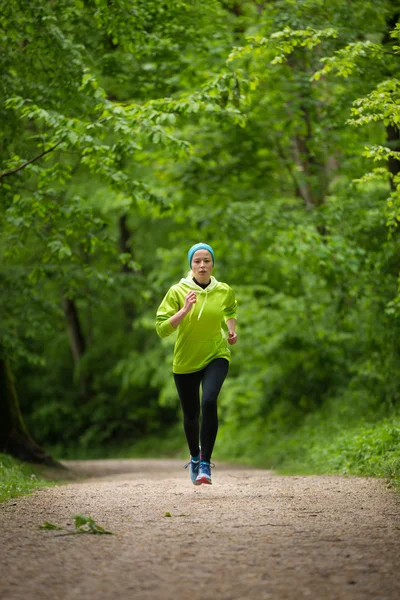 Sportovní mladé běžkyně v lese. — Stock fotografie