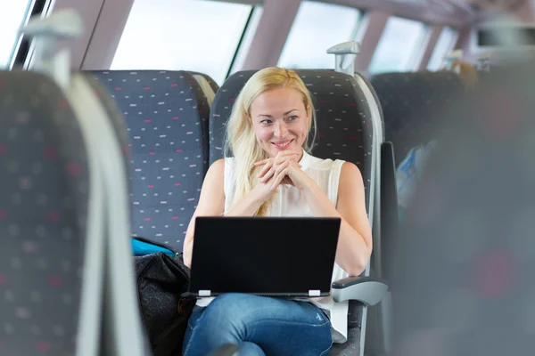 Frau lächelt bei Zugfahrt. — Stockfoto