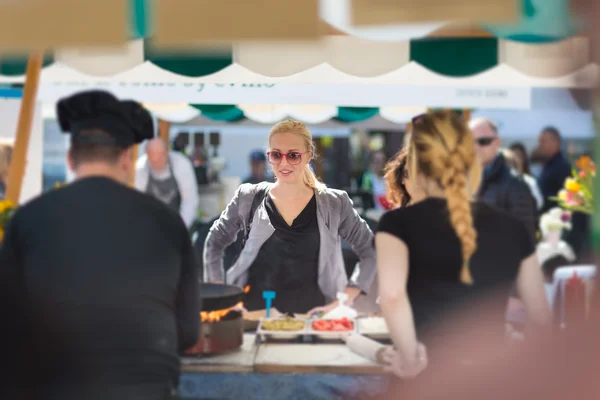 Žena, nákup jídla na ulici food festivalu. — Stock fotografie