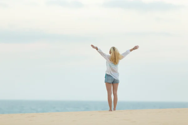 Mujer libre disfrutando de la libertad en la playa al atardecer . —  Fotos de Stock