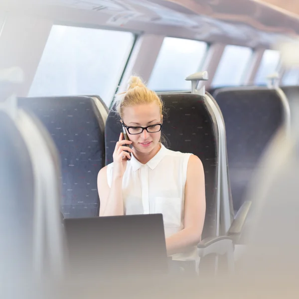 Zakenvrouw die werken terwijl het reizen per trein. — Stockfoto