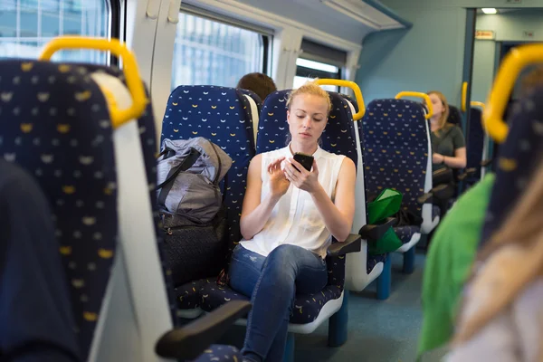 電車で旅行中の携帯電話を使用しての女性. — ストック写真