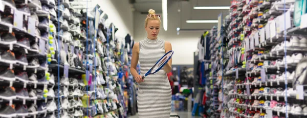 Kobieta zakupy sprzętu sportowego w sportowej przechowywać. — Zdjęcie stockowe