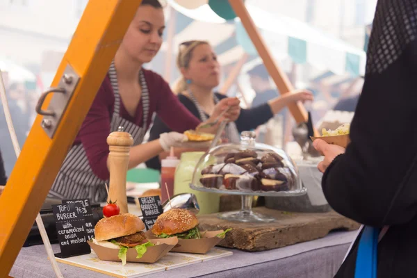 Kobiet serwuje hamburgery na Festiwal żywności w Ljubljanie, w Słowenii. — Zdjęcie stockowe