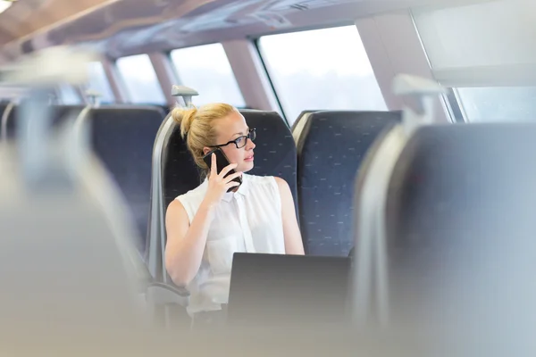 Zakenvrouw die werken terwijl het reizen per trein. — Stockfoto