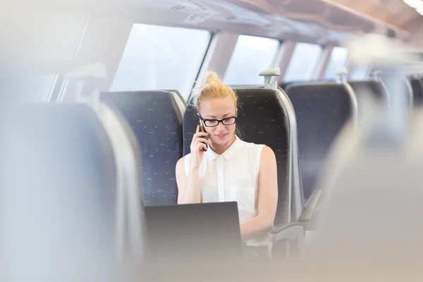 Zakenvrouw die werken terwijl het reizen per trein. — Stockfoto