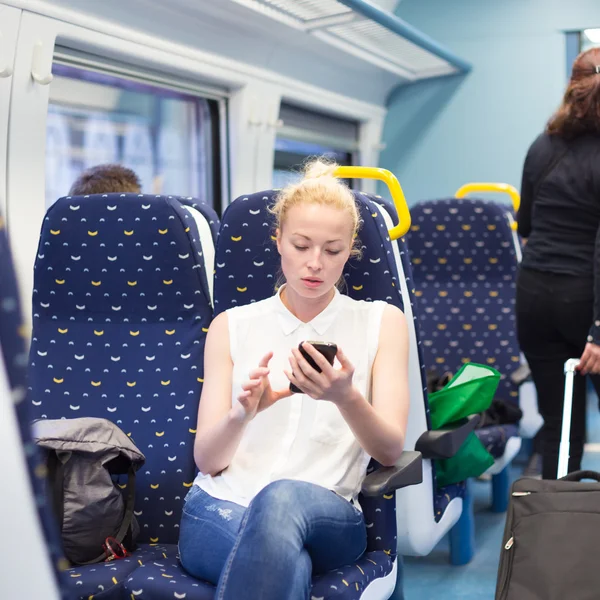 Trenle seyahat ederken cep telefonu kullanan kadın. — Stok fotoğraf