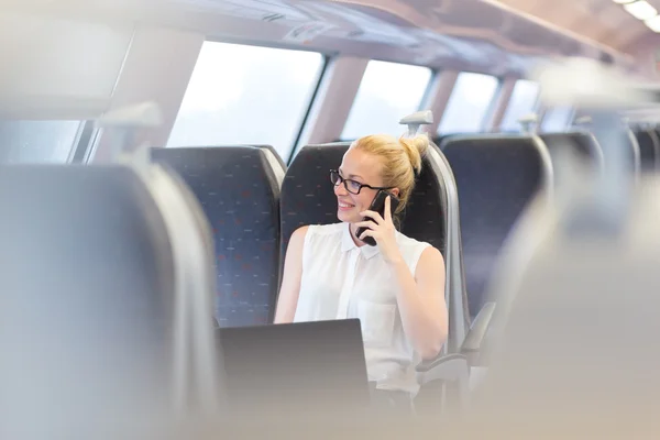 Mujer de negocios que trabaja mientras viaja en tren . — Foto de Stock