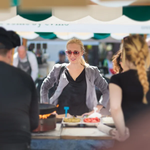 Mujer comprando comida en el festival de comida callejera . — Foto de Stock