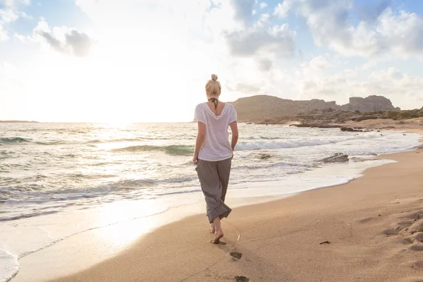 Nő sétál homokos strandon arany óra — Stock Fotó