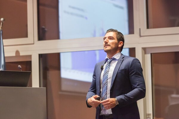 Speaker giving talk at Business Conference.