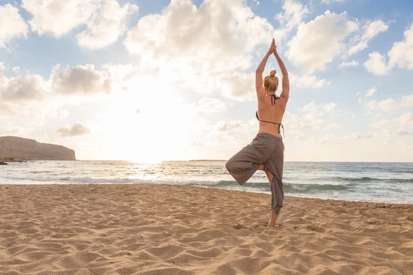 Mujer practicando yoga en la playa de mar al atardecer. —  Fotos de Stock