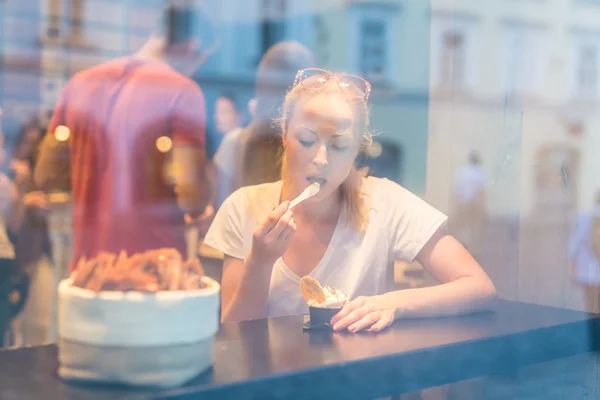 Joven bonita mujer comiendo helado en gelateria . — Foto de Stock