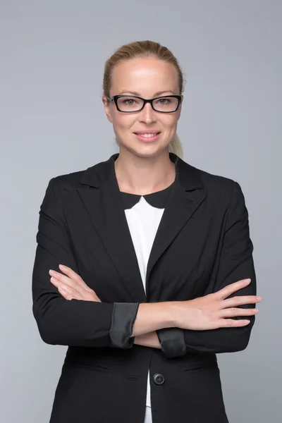 Business woman standing with arms crossed against gray background.. — Stock Photo, Image