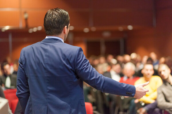 Public speaker giving talk at Business Event.