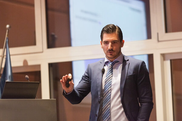 Speaker giving talk at Business Conference.